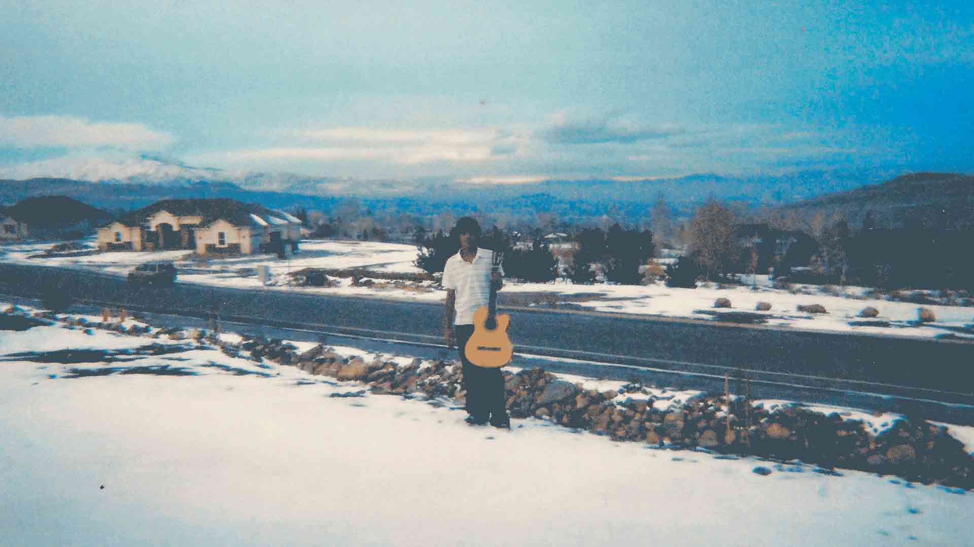 Nocturnal Blessing by Raúl Hurtado Raúl in the snow holding a guitar